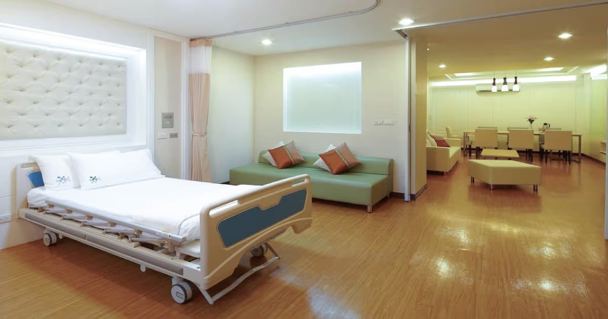 An inpatient room at Phyathai 2 Hospital with a hospital bed, sofa and a separate seating area